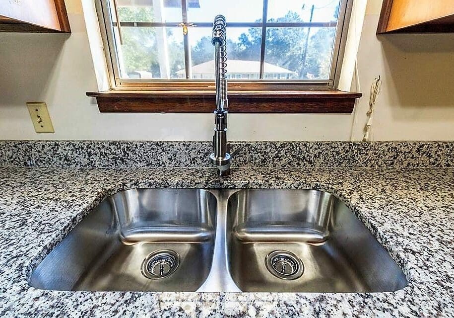 Image of a beautiful premium chrome kitchen sink faucet installed by Honey Bee Plumbing.